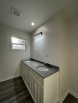 a kitchen that has a sink and a wooden floor