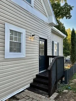a view of a house with a yard and stairs