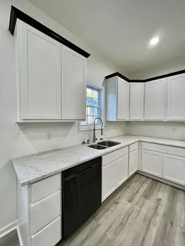 a kitchen with granite countertop white cabinets and white appliances