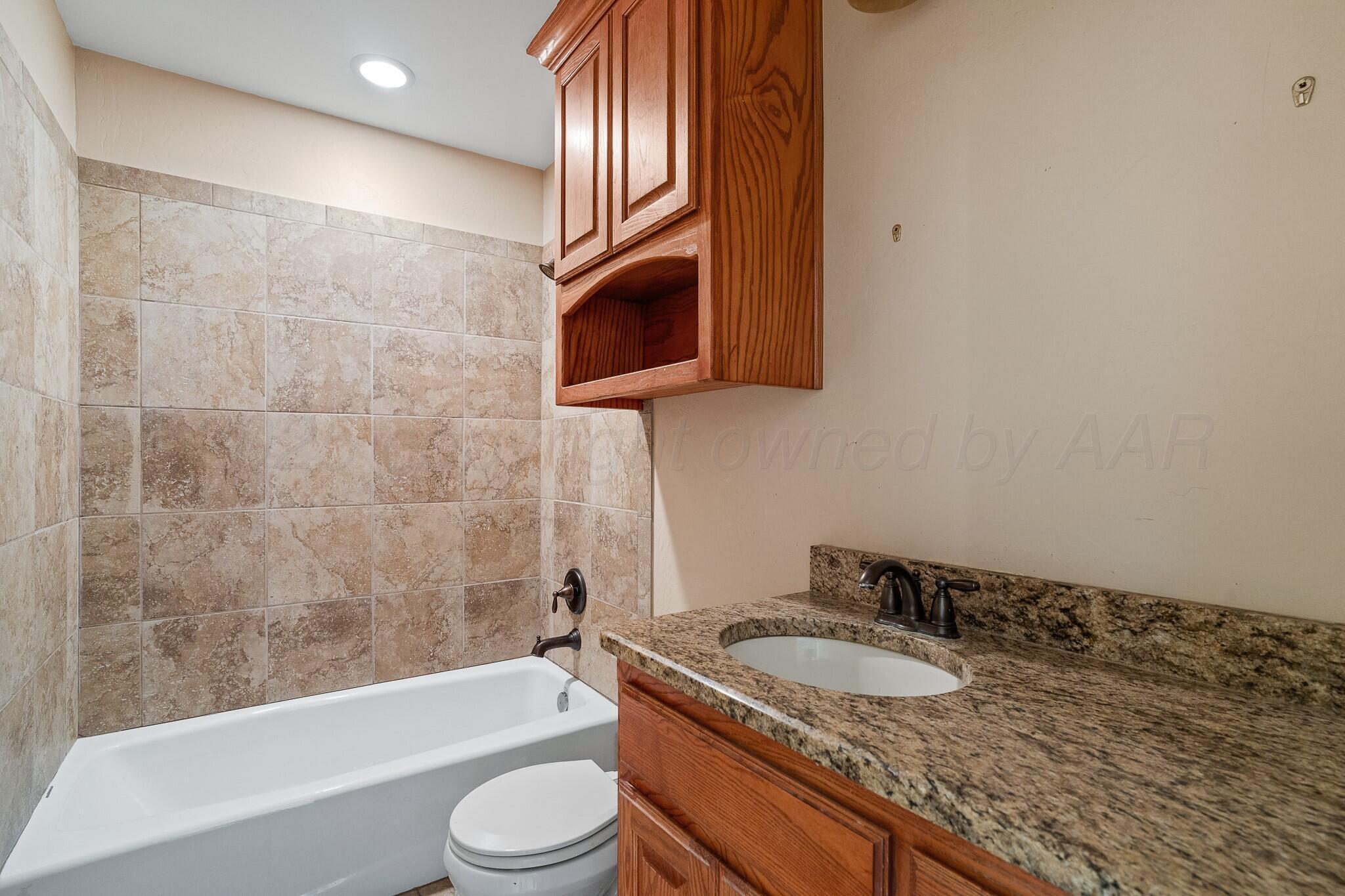6302 Academy Drive Amarillo, TX 79119 - Photo 15 of 19 a bathroom with a granite countertop sink toilet and shower