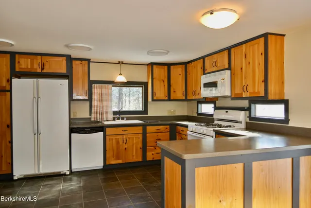a kitchen with stainless steel appliances granite countertop a sink stove and cabinets