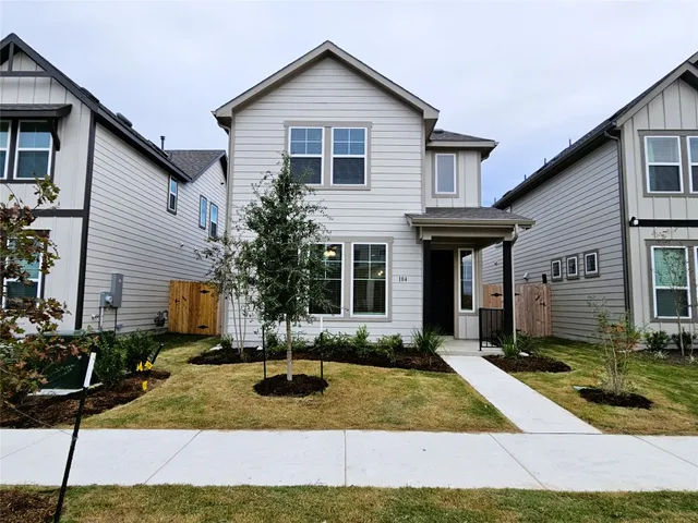 a front view of a house with yard and garage