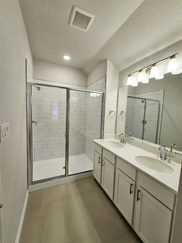 a spacious bathroom with a shower sink and mirror