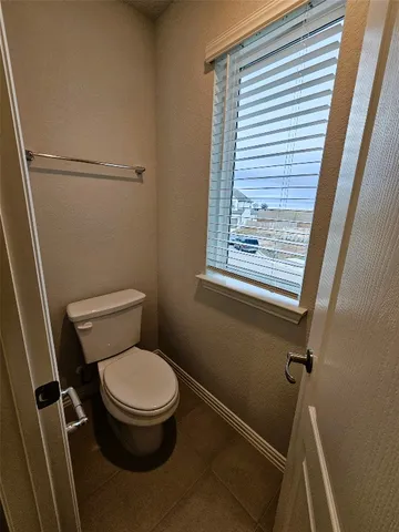 a white toilet sitting next to a window