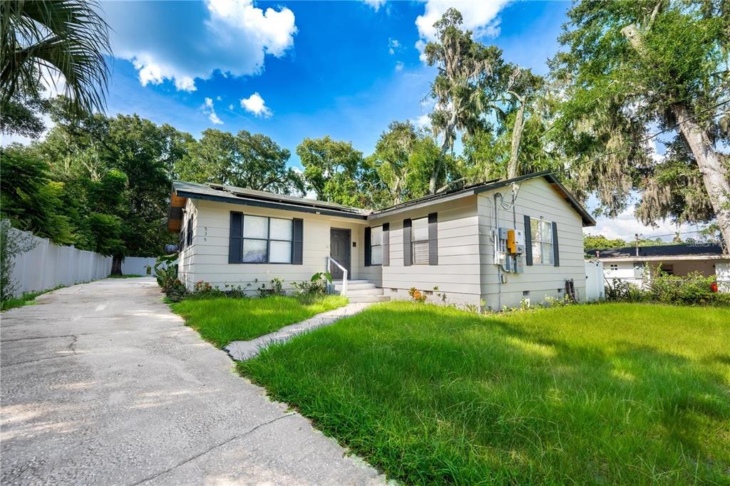 a front view of a house with a yard and trees