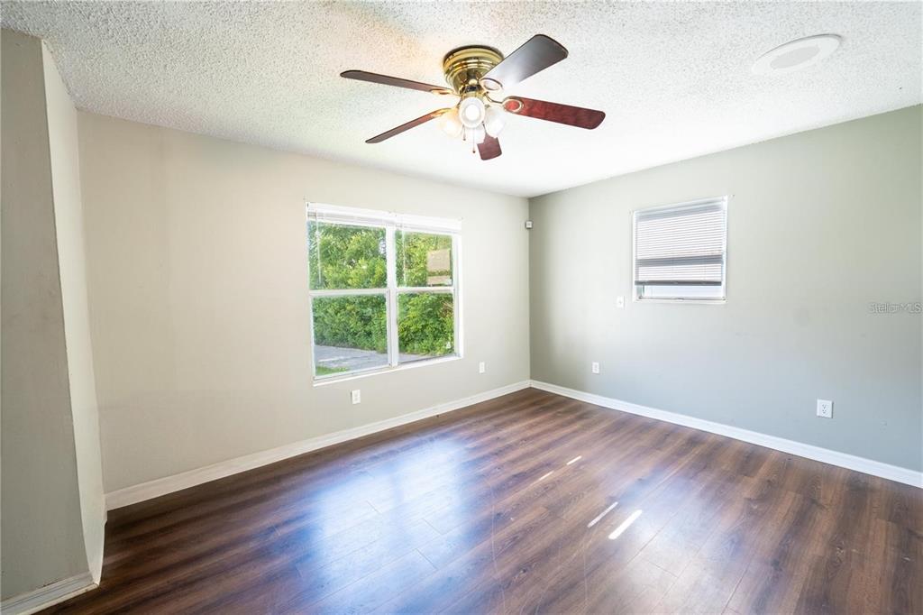 535 West Division Street Deland, FL 32720 - Photo 4 of 25 an empty room with wooden floor ceiling fan and window