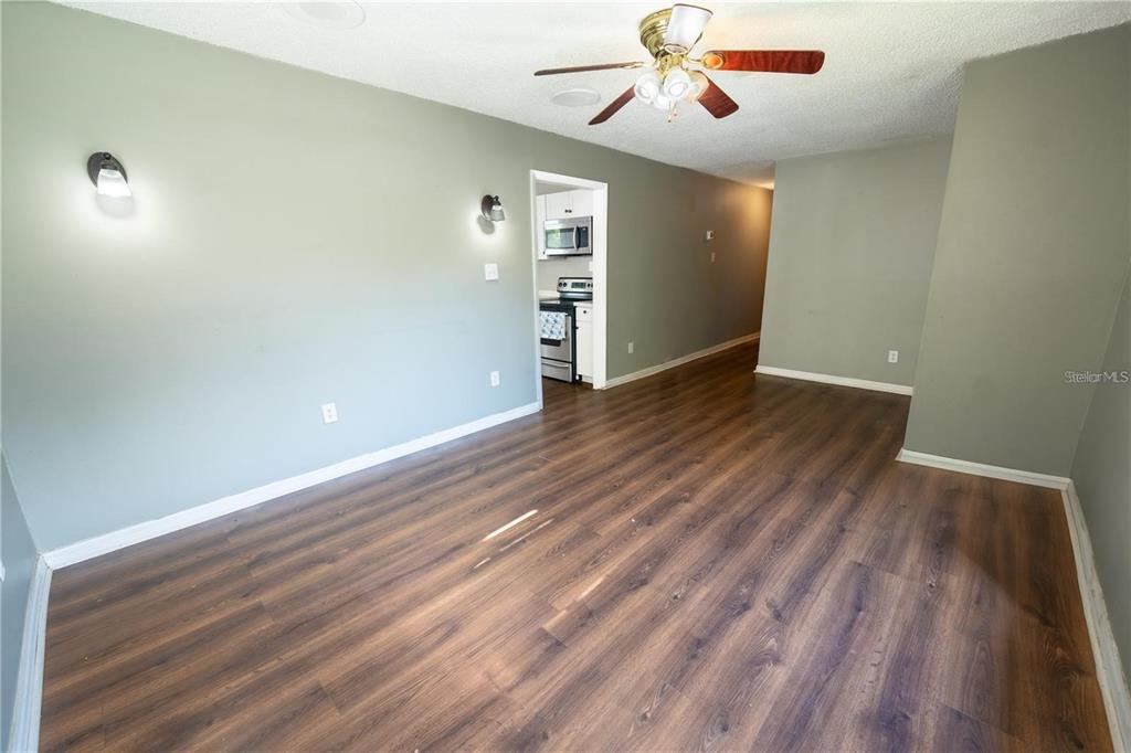 535 West Division Street Deland, FL 32720 - Photo 5 of 25 an empty room with wooden floor chandelier fan and windows
