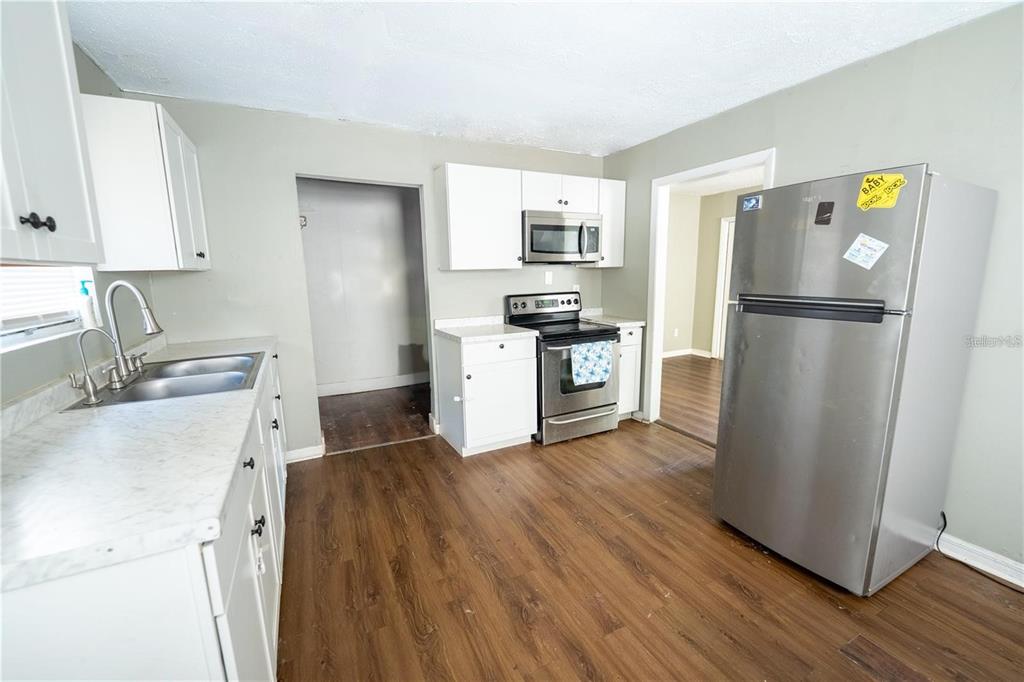535 West Division Street Deland, FL 32720 - Photo 8 of 25 a kitchen with a refrigerator sink and wooden floor