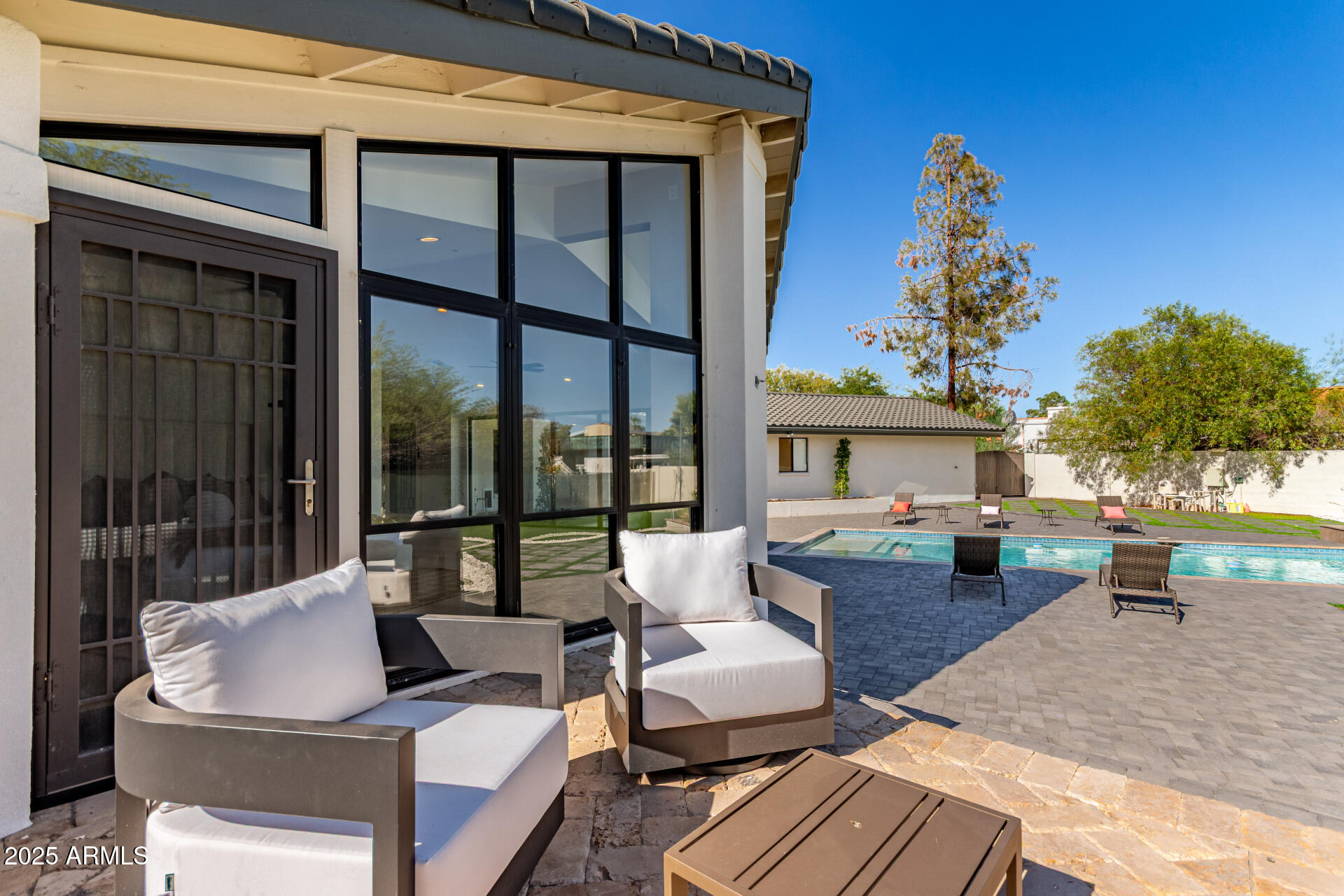3301 East Rovey Avenue Paradise Valley, AZ 85253 - Photo 98 of 105 a view of a patio with couches and table and chairs with wooden floor and fence
