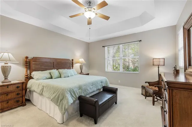 a bedroom with a bed couches and a flat tv screen