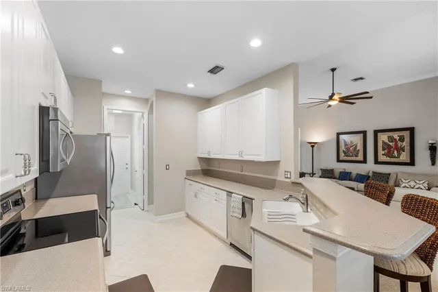 a large kitchen with stainless steel appliances granite countertop a sink and a refrigerator