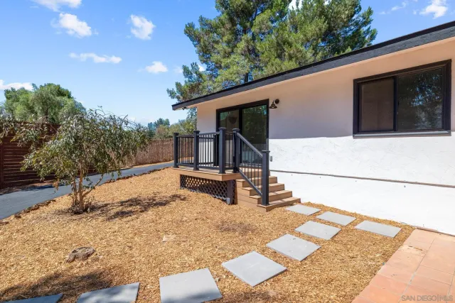 a living room with a table chairs and a view of kitchen