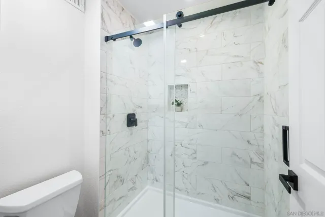 an empty room with a window and ceiling fan