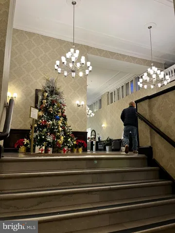 a view of a lobby with a chandelier and living room view