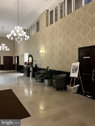 a living room with furniture a chandelier and a dining table