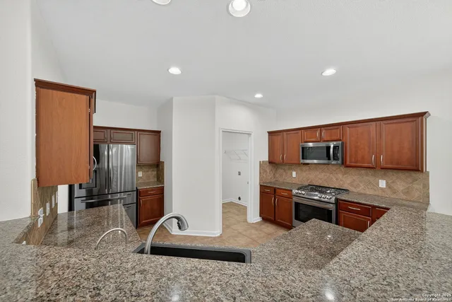 a kitchen with stainless steel appliances granite countertop a sink microwave and stove