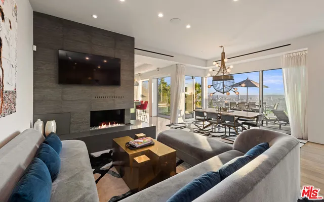 a kitchen with stainless steel appliances granite countertop a stove and a view of living room