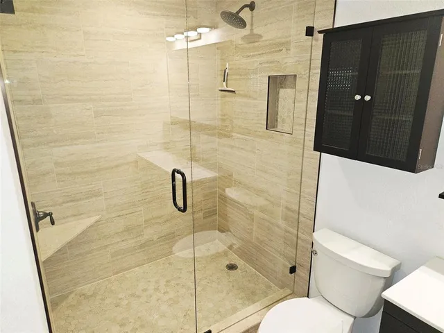 a bathroom with a shower and toilet