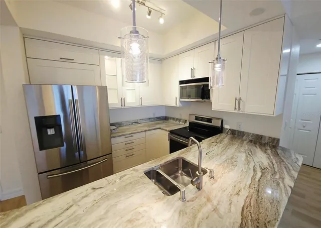 a kitchen with stainless steel appliances a refrigerator sink and microwave