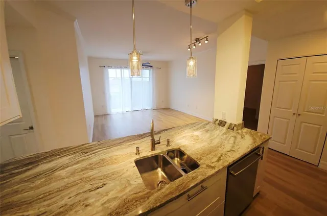 a open kitchen with kitchen island a stove and wooden floor