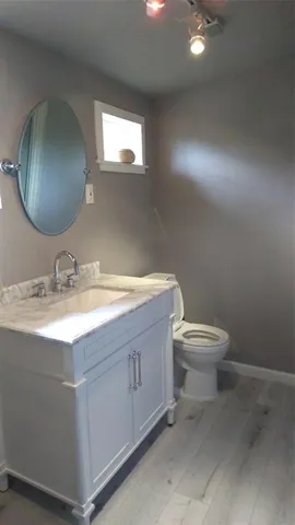a bathroom with a granite countertop toilet sink and mirror