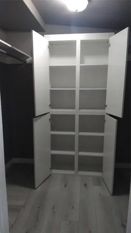 a view of walk in closet with empty racks