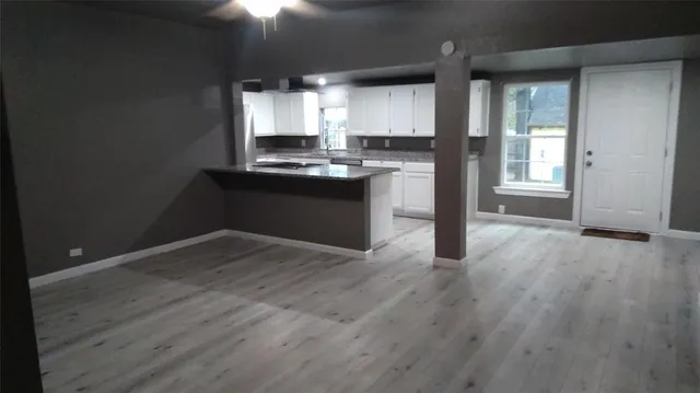 a kitchen with granite countertop wooden floors and wide window