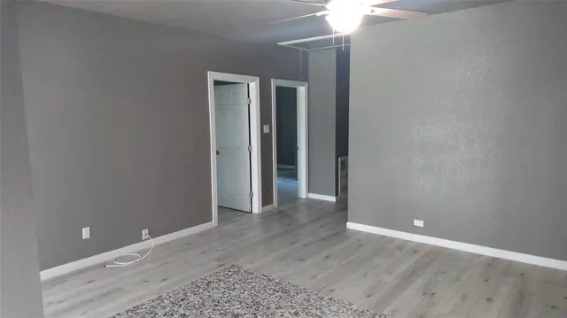 a view of an empty room with a chandelier fan