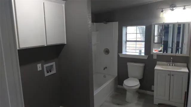 a bathroom with a toilet sink a vanity and window
