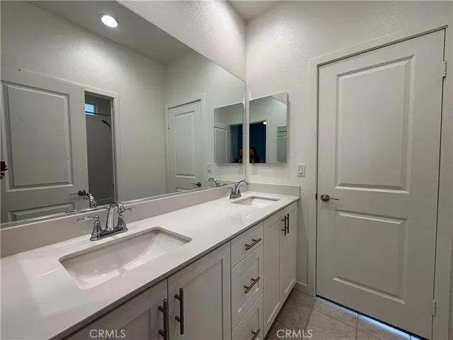 a bathroom with a double vanity sink and mirror