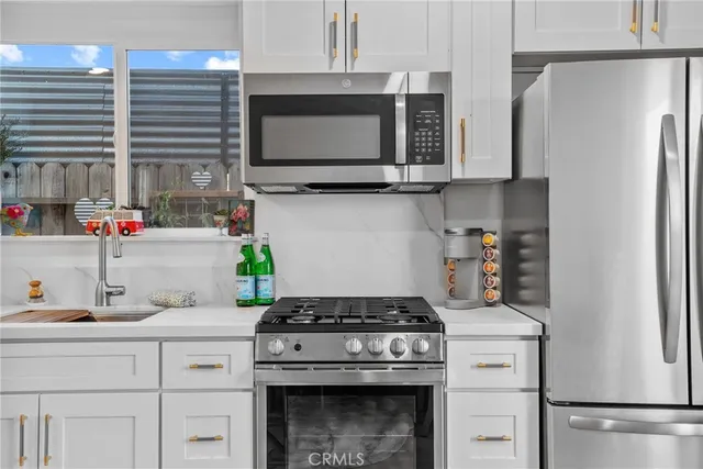 a kitchen with stainless steel appliances a stove a microwave and cabinets