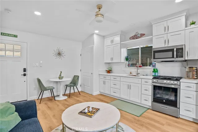 a kitchen with stainless steel appliances granite countertop a stove a sink a dining table and chairs