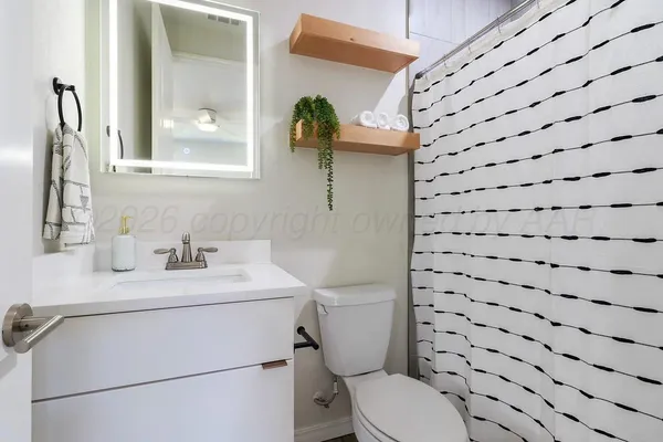 a bathroom with a toilet sink and mirror