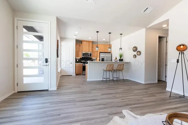 a kitchen with stainless steel appliances granite countertop a refrigerator and a wooden cabinets