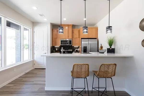 a kitchen with a table chairs refrigerator and sink