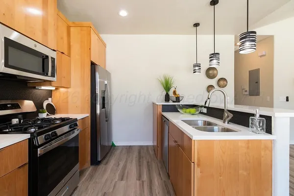 a kitchen that has a sink a stove and a microwave