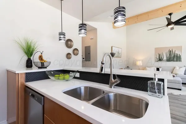 a kitchen with a sink a faucet a chandelier and living room view