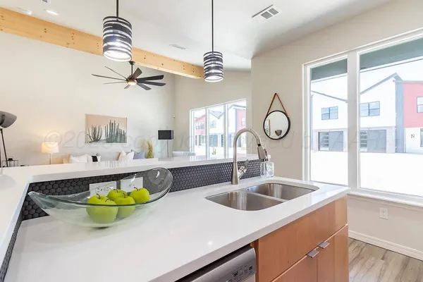 a bathroom with a sink a faucet a light fixture and a window