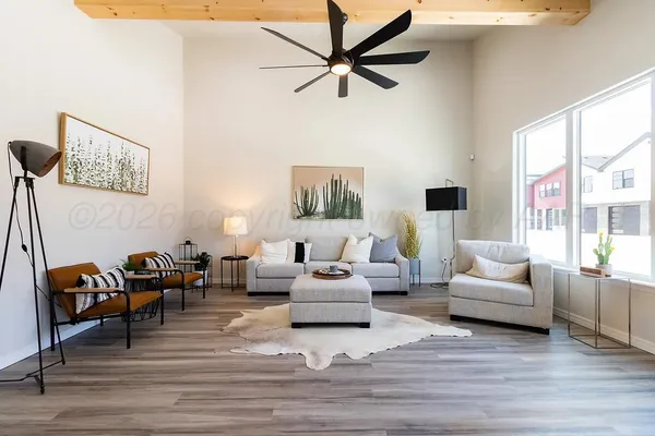 a living room with furniture flat screen tv and a large window