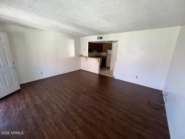 a view of empty room with wooden floor