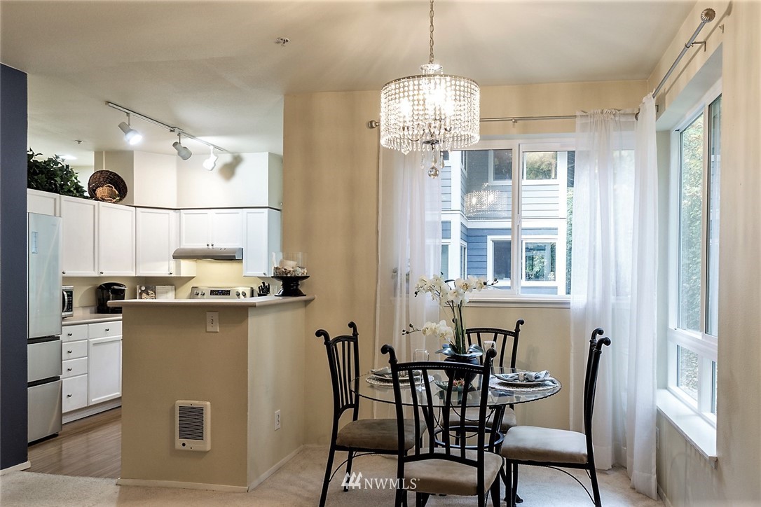 3918 243rd Place Southeast, Unit F304 Bothell, WA 98021 - Photo 2 of 25 a view of a dining room with furniture wooden floor and chandelier