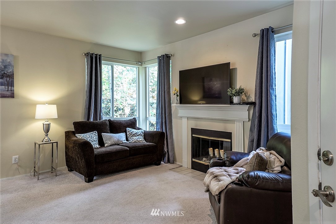3918 243rd Place Southeast, Unit F304 Bothell, WA 98021 - Photo 13 of 25 a living room with furniture a flat screen tv and a fireplace
