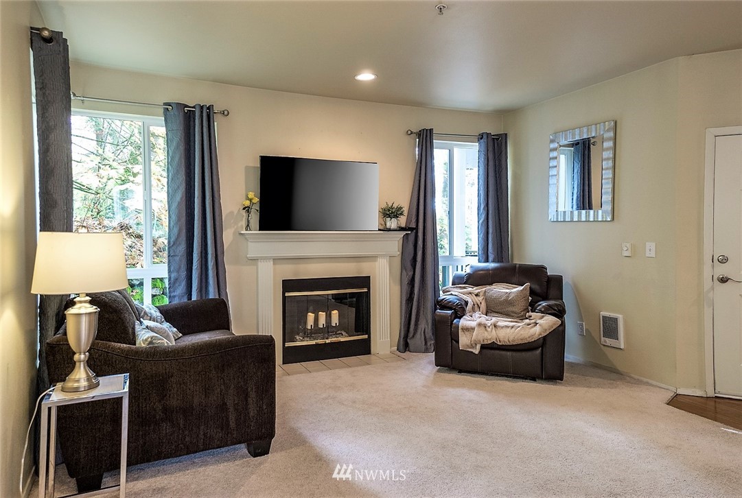 3918 243rd Place Southeast, Unit F304 Bothell, WA 98021 - Photo 4 of 25 a living room with furniture and a fireplace