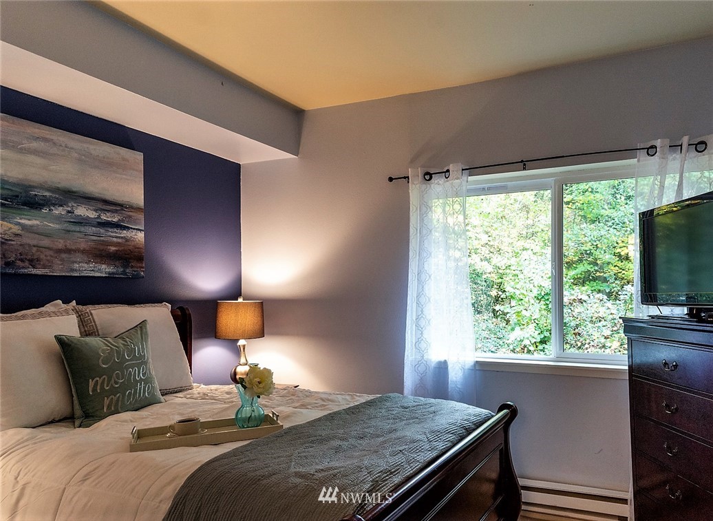 3918 243rd Place Southeast, Unit F304 Bothell, WA 98021 - Photo 5 of 25 a bedroom with a bed and a large window