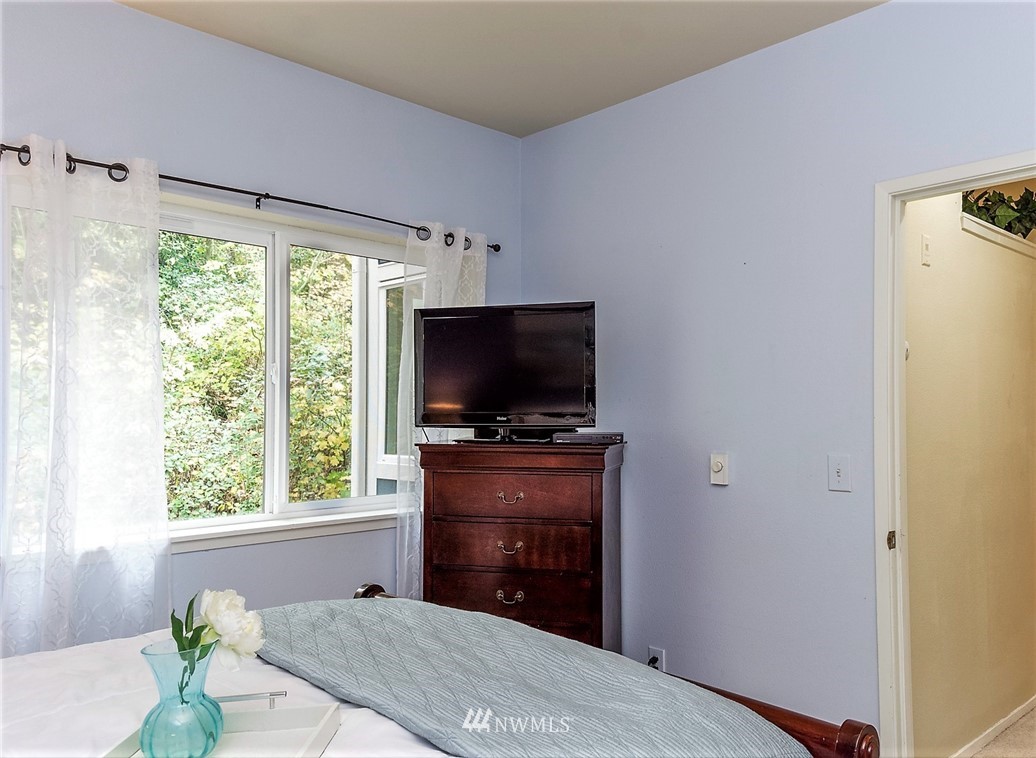3918 243rd Place Southeast, Unit F304 Bothell, WA 98021 - Photo 8 of 25 a bedroom with a bed and a flat screen tv
