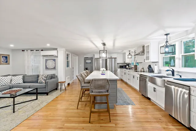 a living room with kitchen island granite countertop furniture and a kitchen view