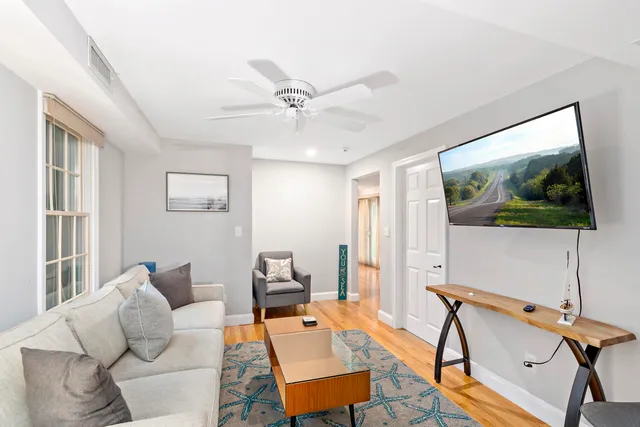 a living room with furniture a flat screen tv and a window