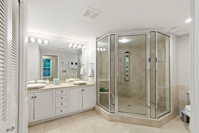 a bathroom with a shower sink mirror and toilet