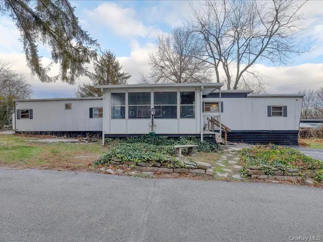 a view of a house with a yard and large tree