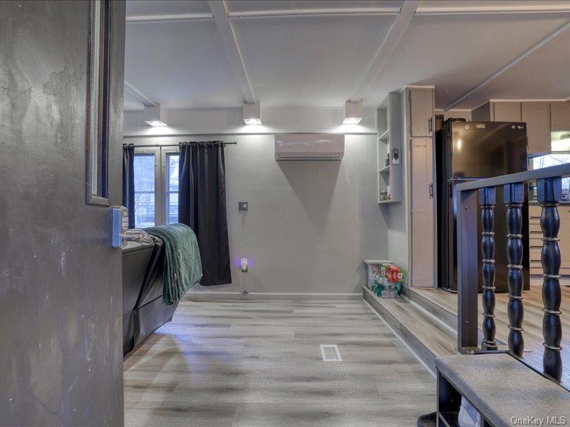 165 Lattintown Road, Unit LOT 60 Newburgh, NY 12550 - Photo 10 of 24 Below grade area with light wood finished floors, a wall mounted air conditioner, and freestanding refrigerator